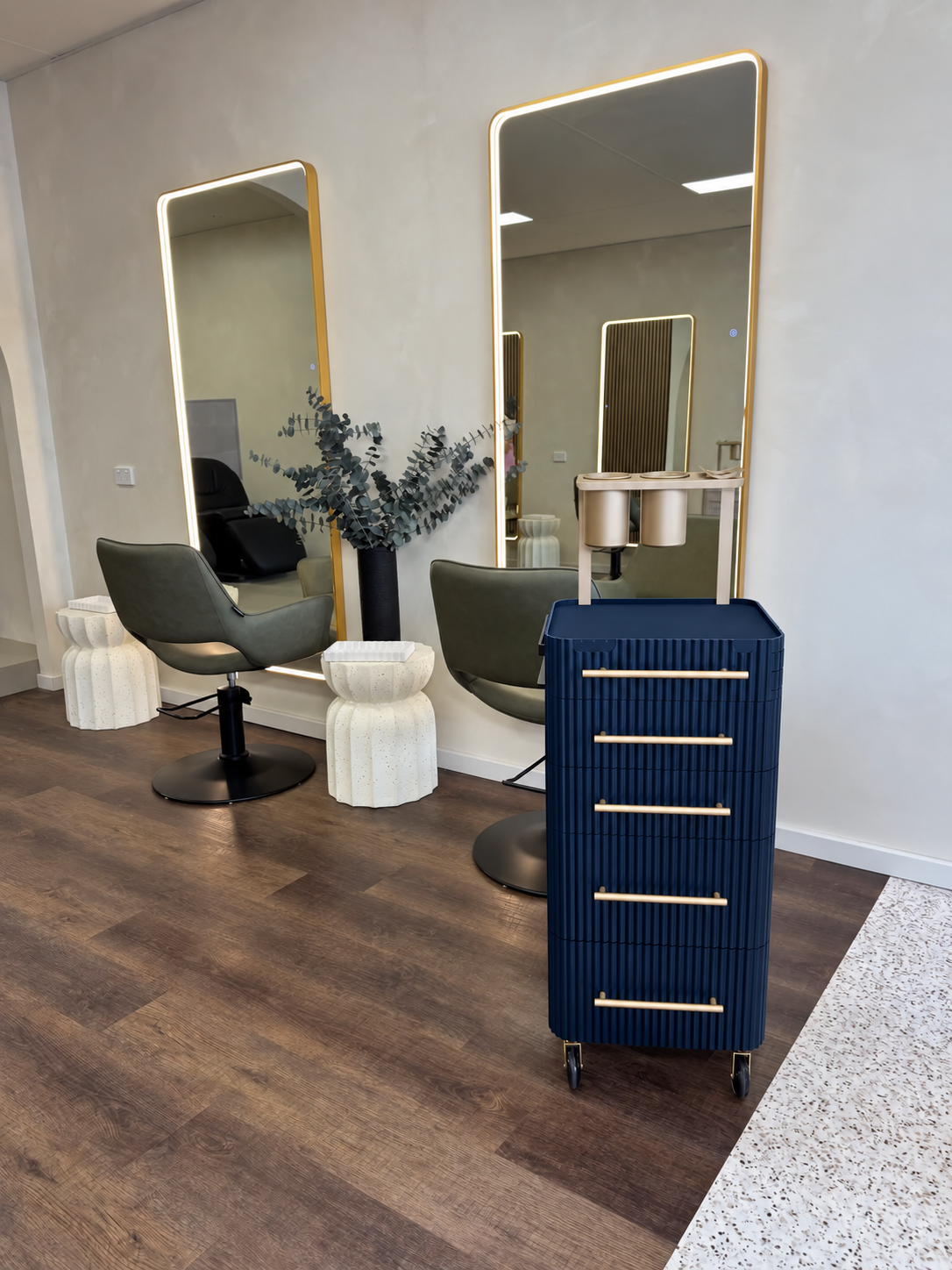Navy & Gold salon trolley beside styling chairs and illuminated mirrors