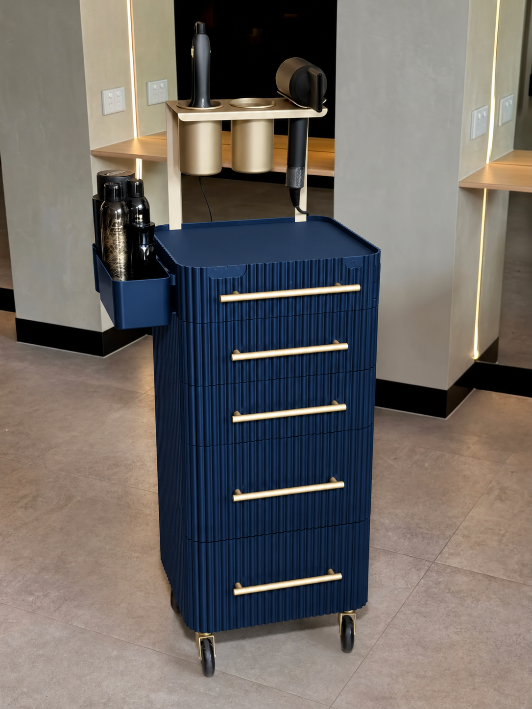 Navy & Gold fluted salon trolley with gold-coloured fittings and castor wheels in a salon