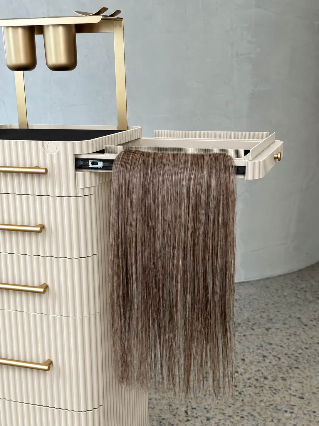 Close-up of an ivory fluted salon trolley with gold fittings and an extended side holder